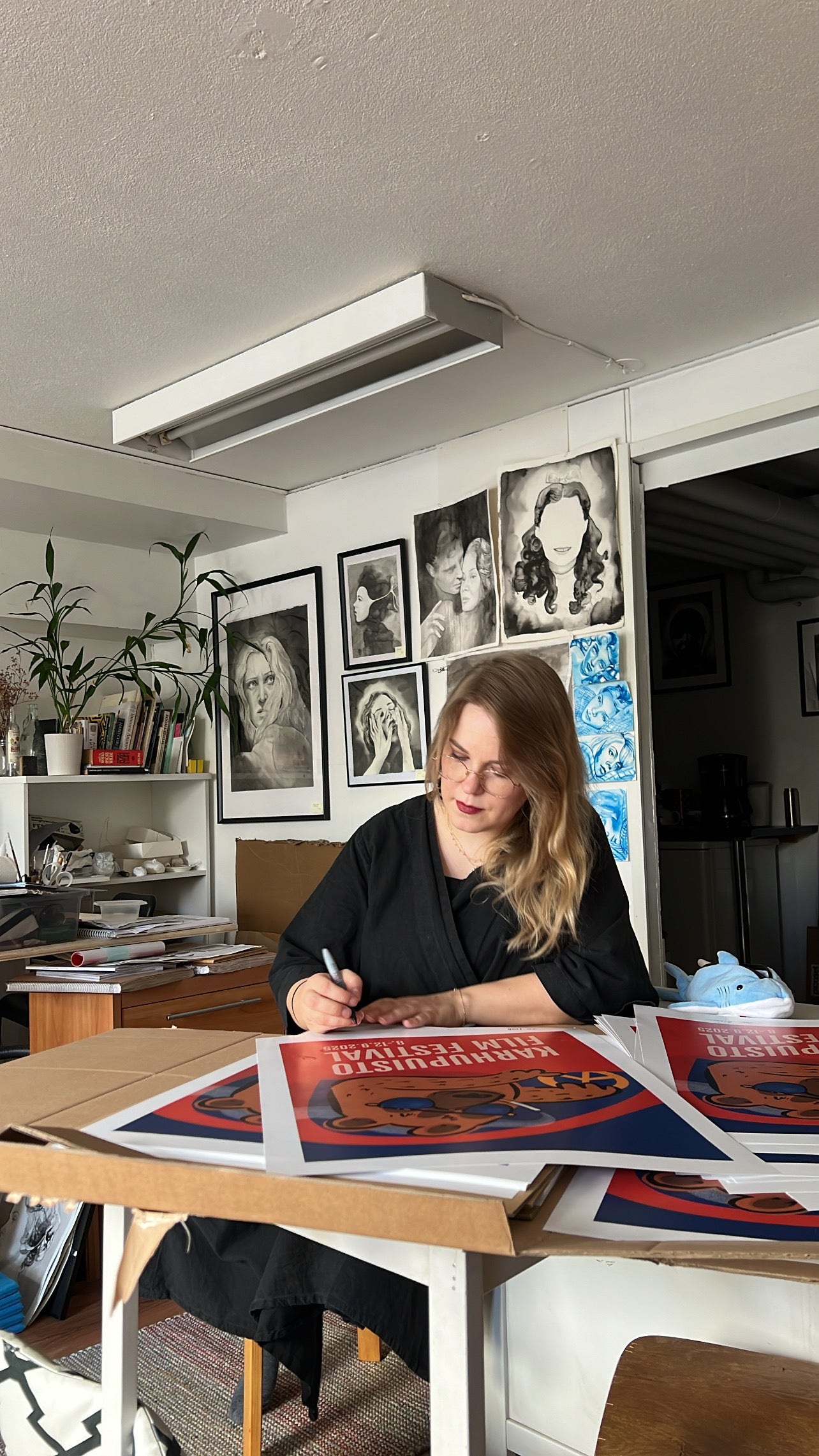 Taiteilija Taru Liikanen signeeraamassa Karhupuisto Film Festival taidejulisteita