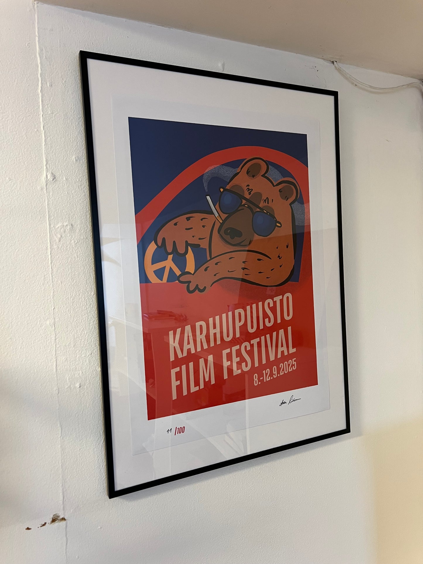 Karhupuisto Film Festival taidejuliste kehystettynä seinällä