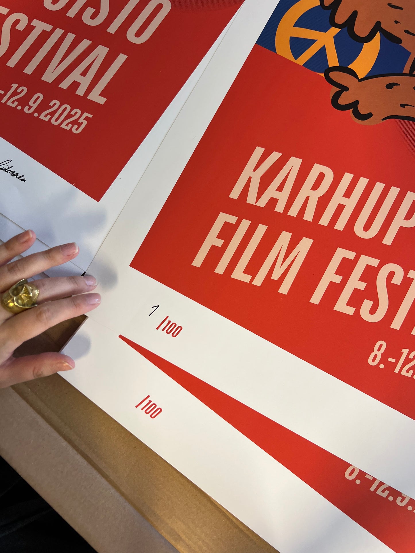 Taiteilija Taru Liikanen signeeraamassa Karhupuisto Film Festival taidejulisteita