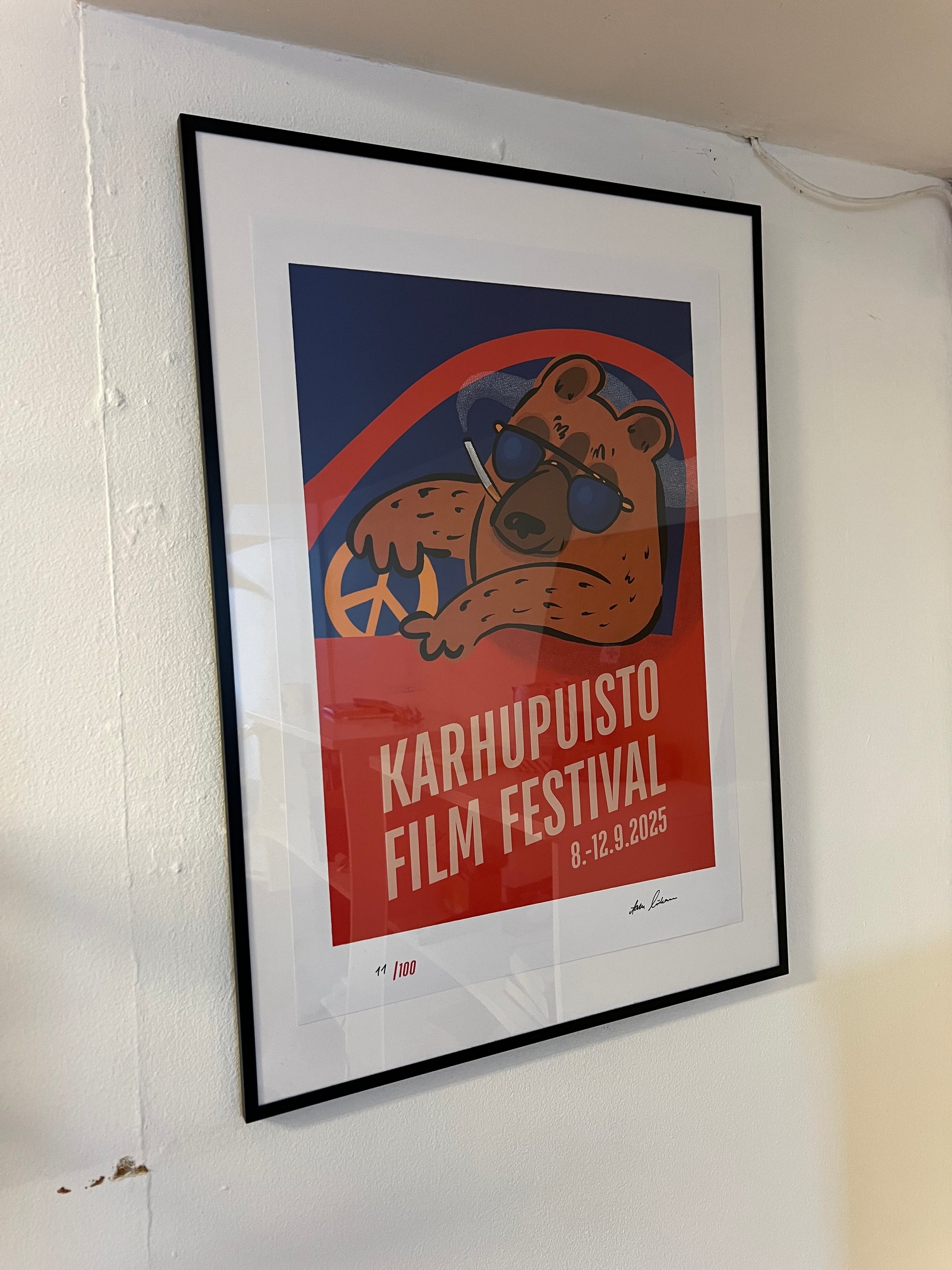 Karhupuisto Film Festival taidejuliste kehystettynä seinällä