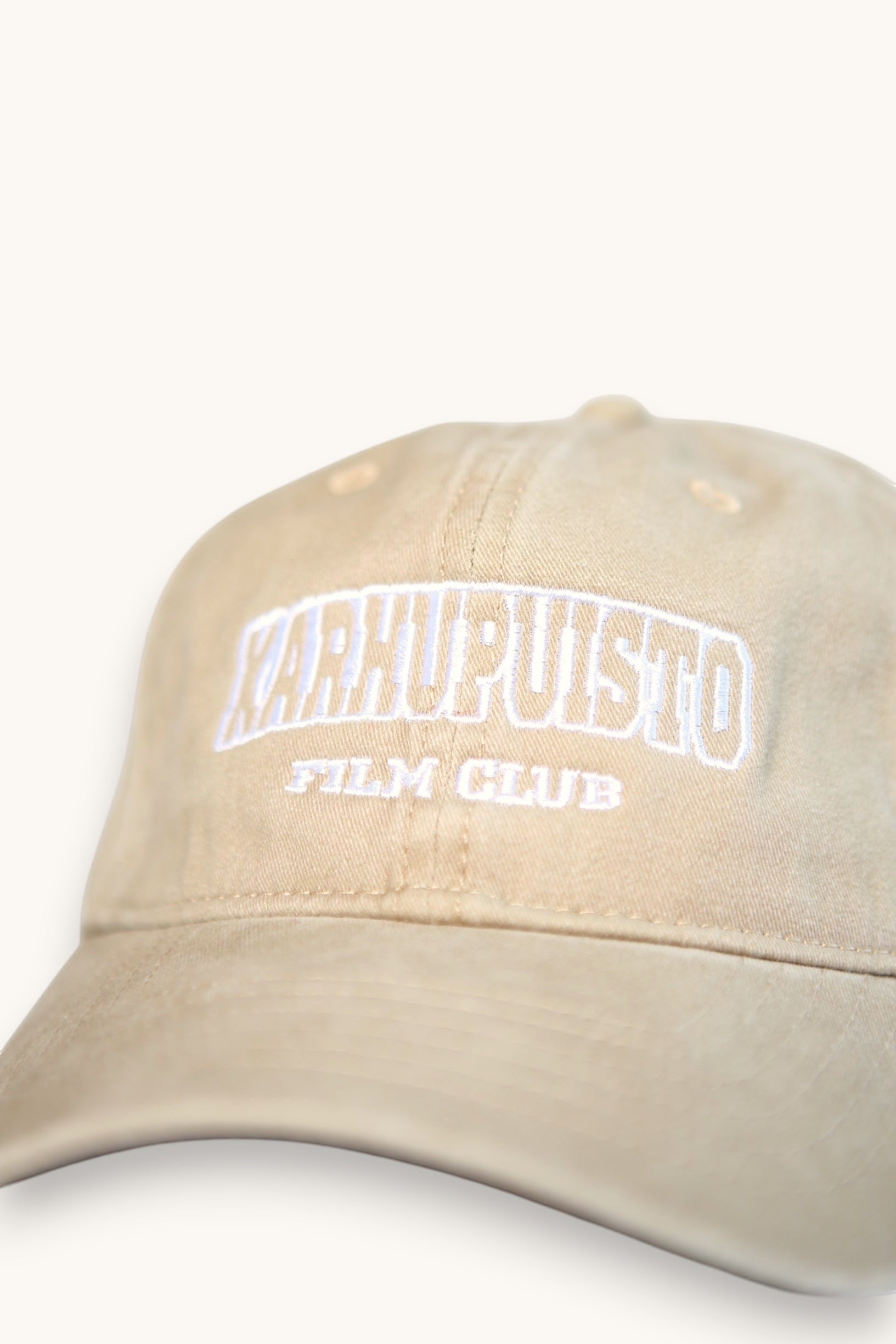 Karhupuisto Film Festival beige cotton baseball cap with white collegiate-style embroidered lettering on the front.