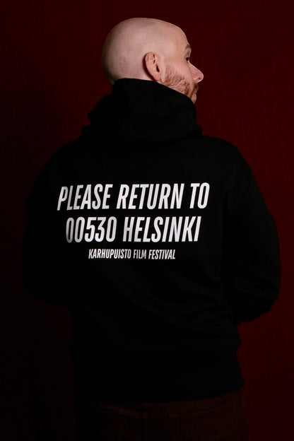 Karhupuisto Film Festival black unisex hoodie with white back print on a model against a dark red background