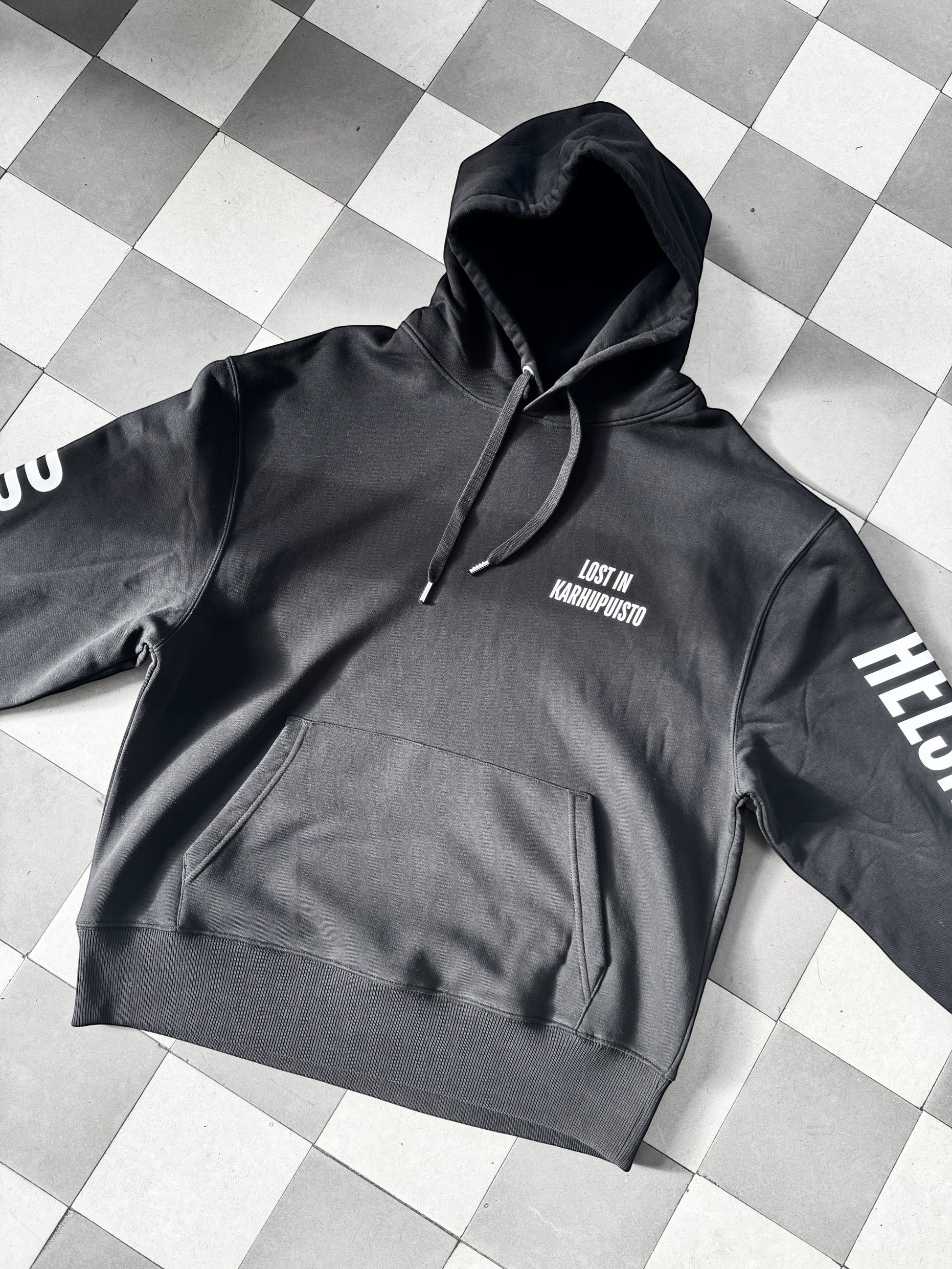 Karhupuisto Film Festival black unisex hoodie with white Lost in Karhupuisto print and Helsinki sleeve details.