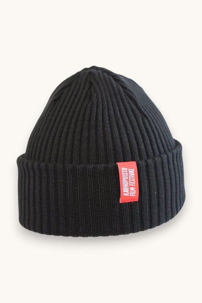 Karhupuisto Film Festival black ribbed knit beanie with a folded cuff and a vibrant red branded woven label.