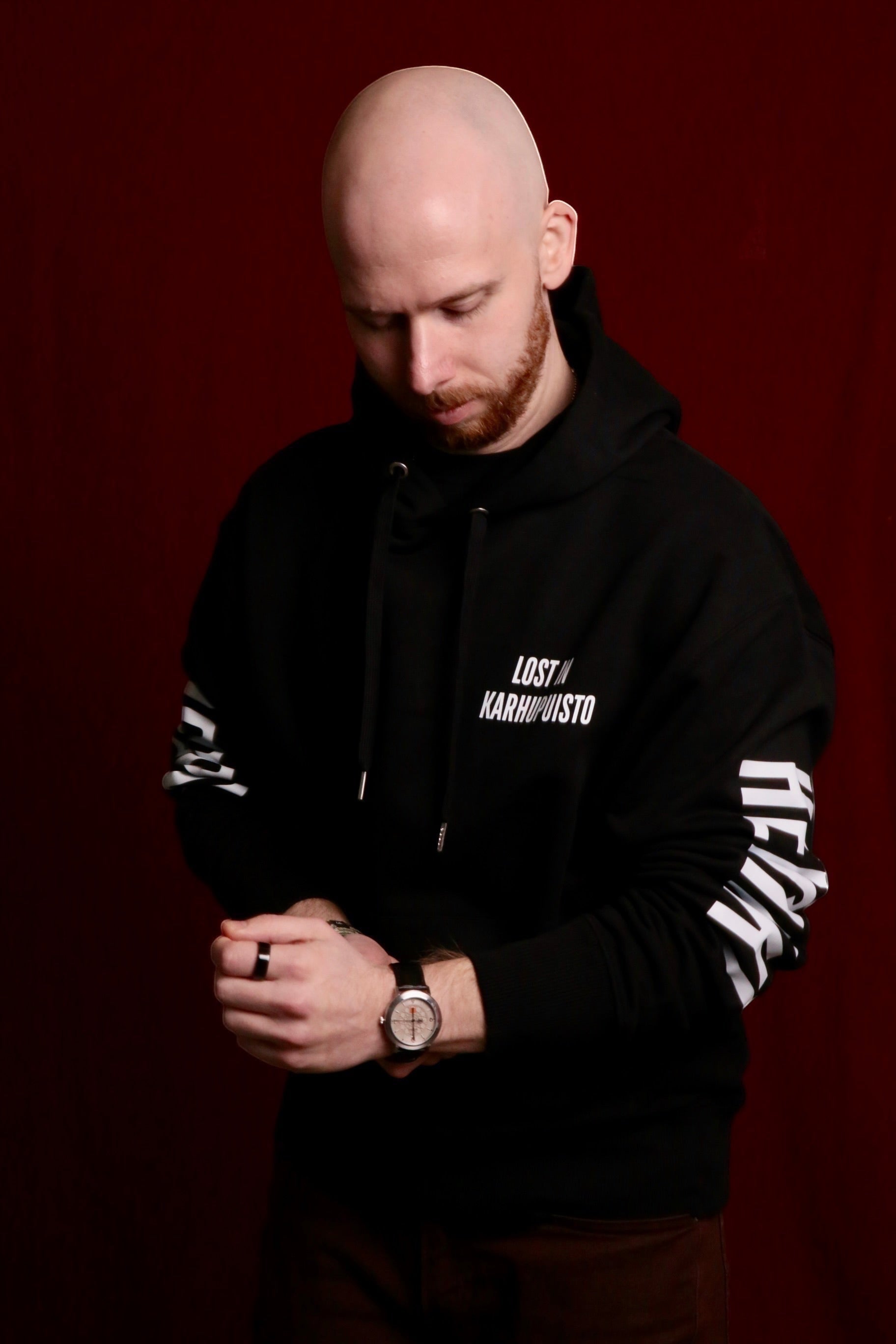 Karhupuisto Film Festival black unisex hoodie with white Lost in Karhupuisto chest print worn by a man