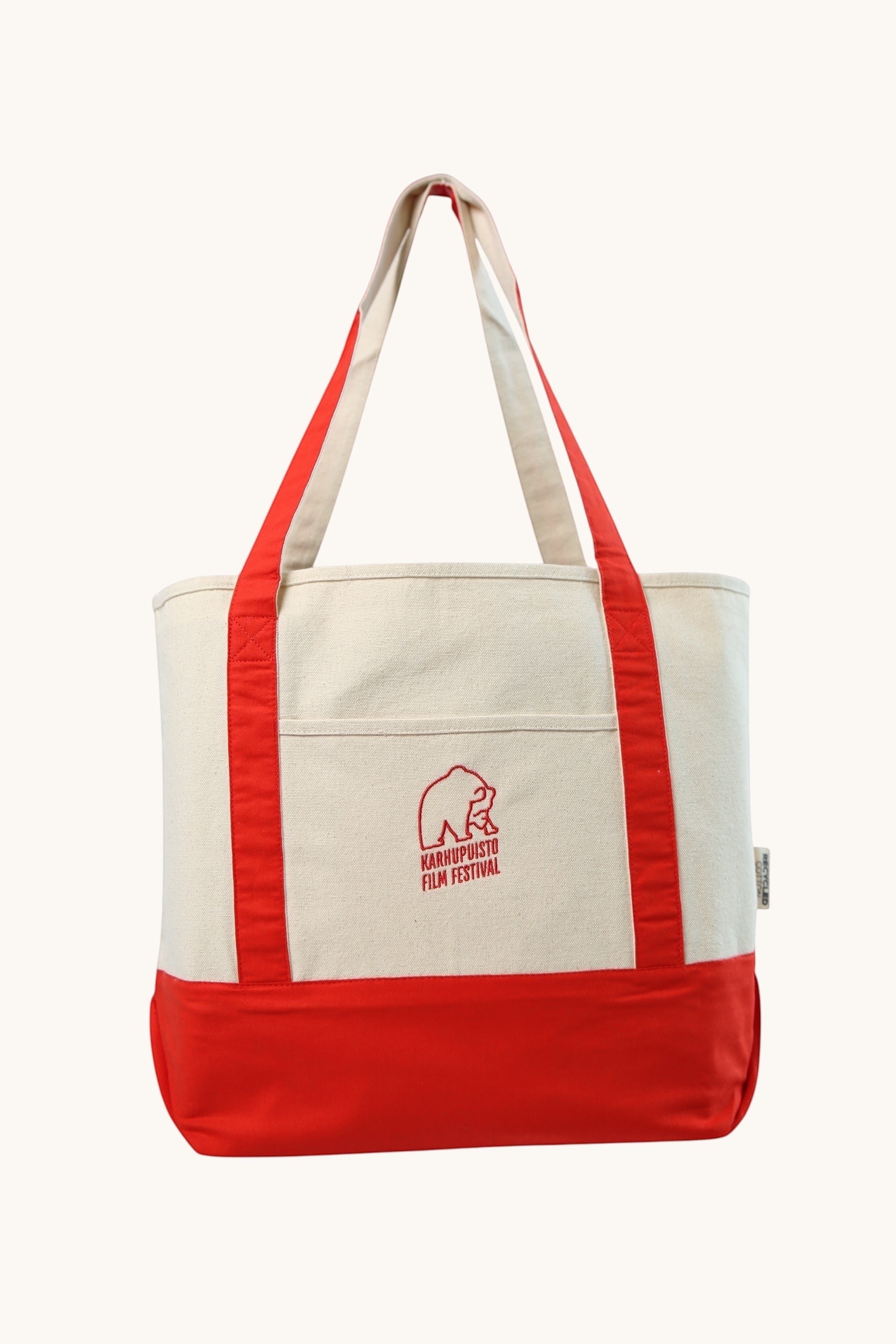 Karhupuisto Film Festival recycled cotton canvas tote bag in cream with red handles, base, and bear logo print.