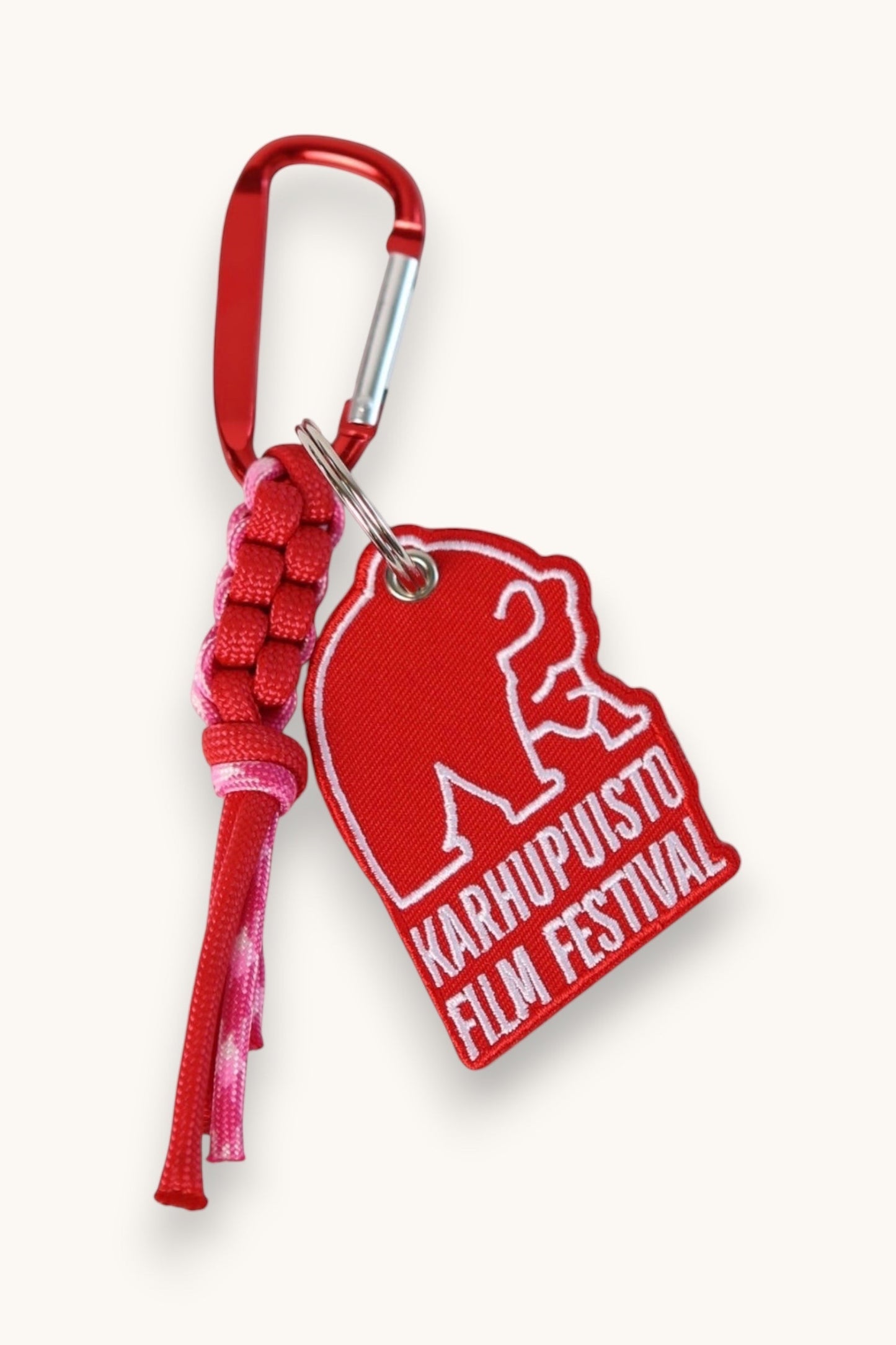 Karhupuisto Film Festival red bear keychain with pink paracord and carabiner clip for bags or keys.