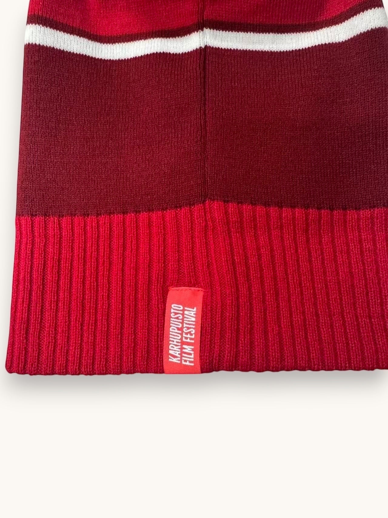 Karhupuisto Film Festival red and burgundy knit beanie with white stripe and woven brand label on the ribbed cuff