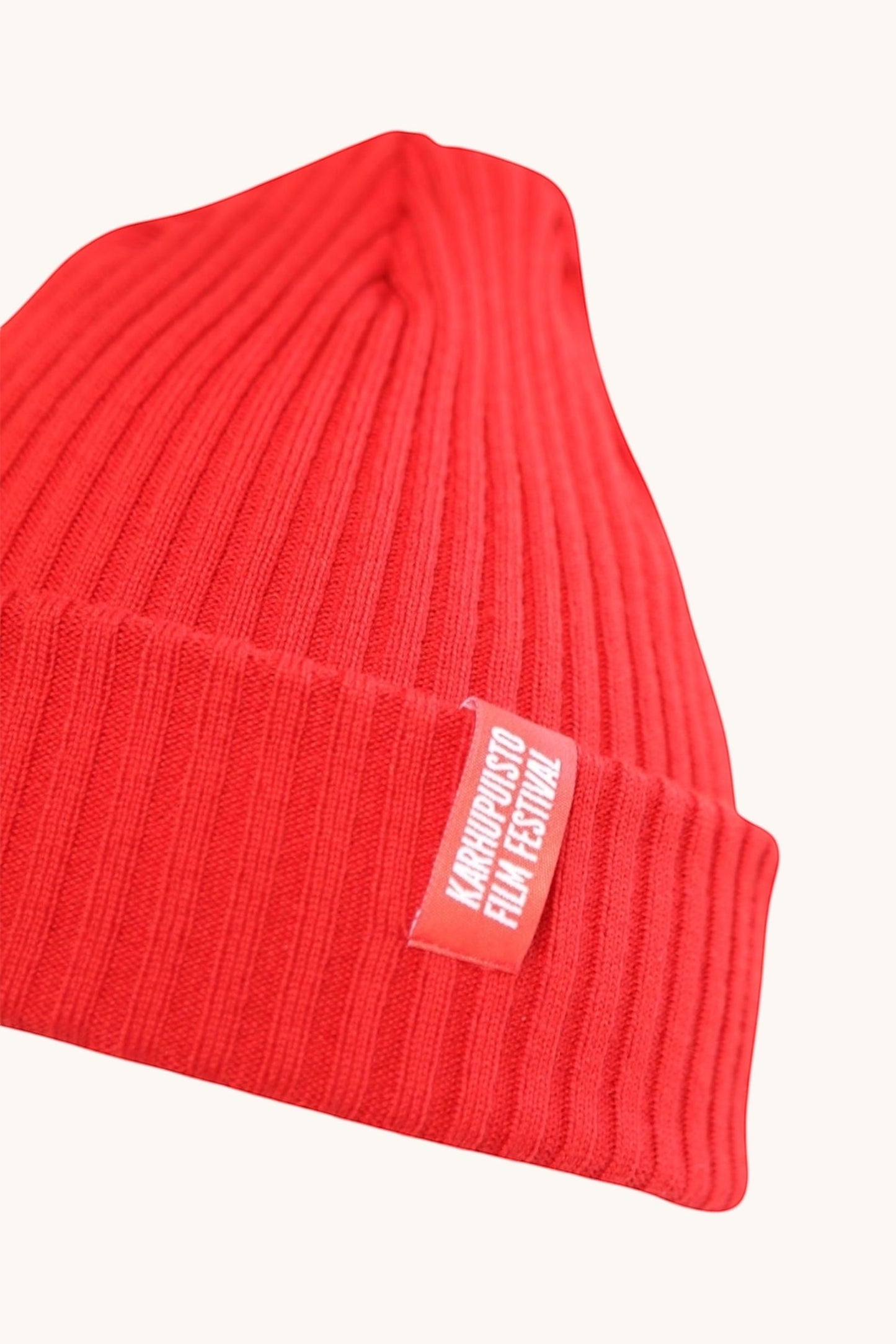 Karhupuisto Film Festival vibrant red ribbed knit beanie with a branded woven label on the cuff.