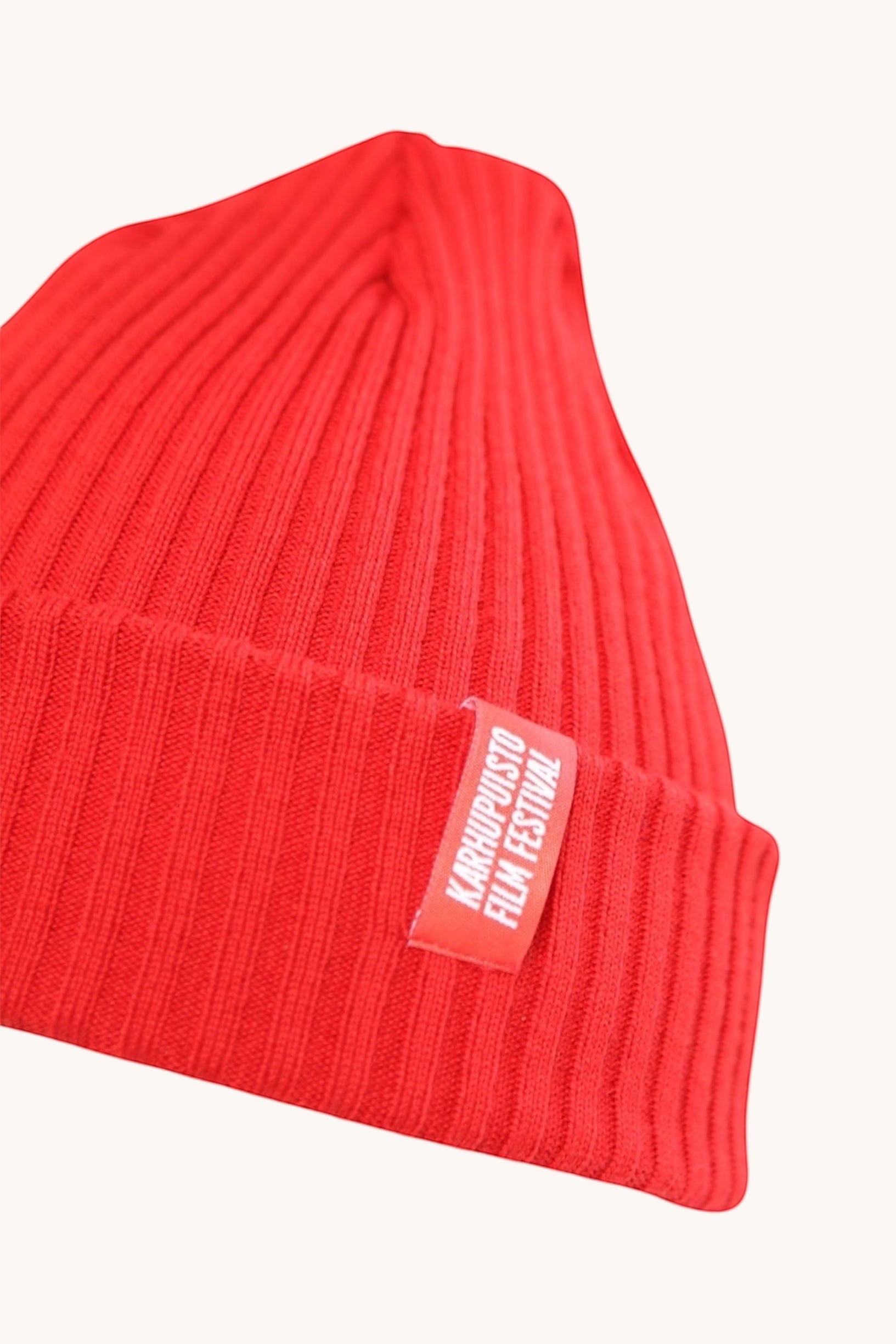 Karhupuisto Film Festival vibrant red ribbed knit beanie with a branded woven label on the cuff.