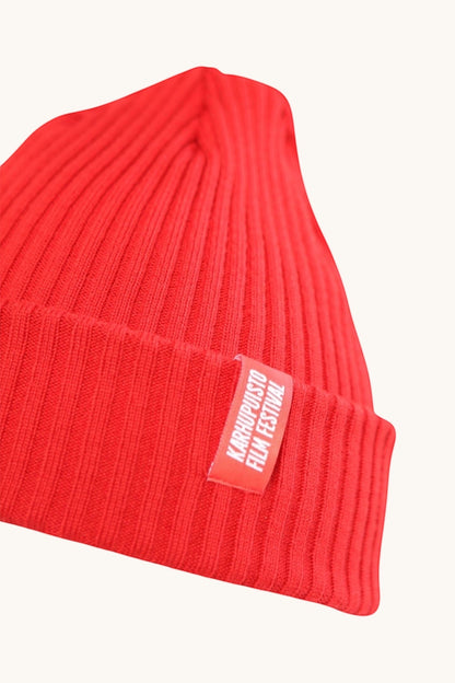 Karhupuisto Film Festival vibrant red ribbed knit beanie with a branded woven label on the cuff.