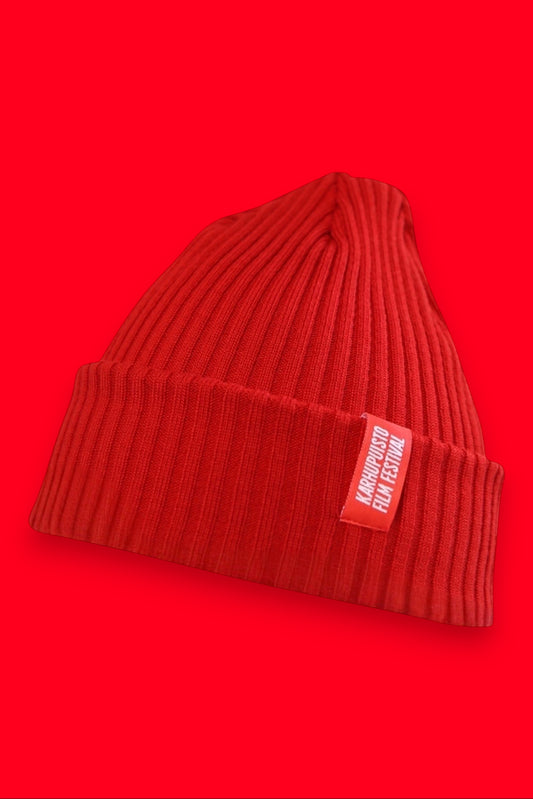 Karhupuisto Film Festival vibrant red ribbed knit beanie with a branded woven label on the cuff.